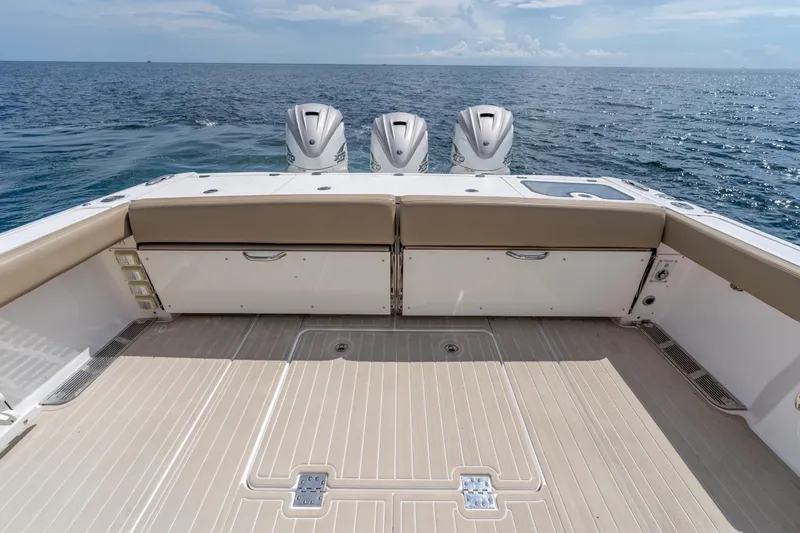 Golden Hour Yacht Photos Pics 2021 Everglades 395 Center Console boat with triple outboard engines on open sea.