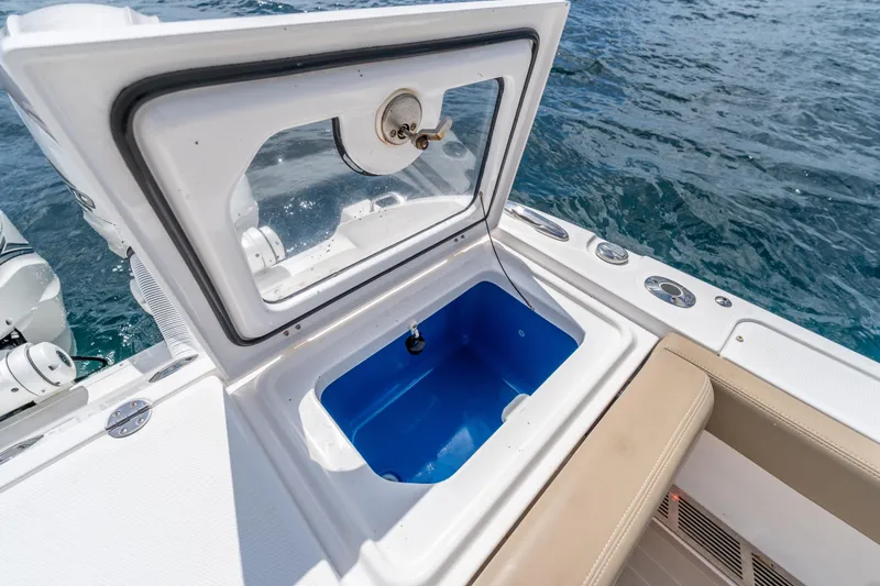 Golden Hour Yacht Photos Pics Open storage compartment on 2021 Everglades 395 Center Console boat, with ocean in background.