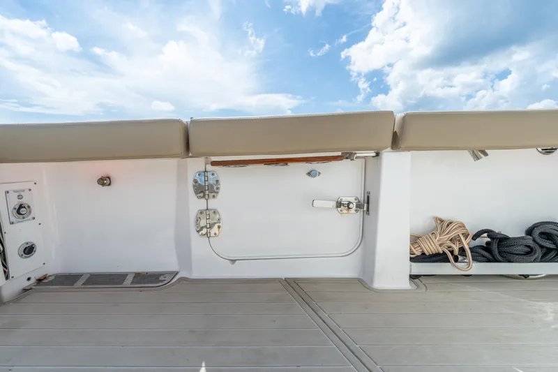 Golden Hour Yacht Photos Pics 2021 Everglades 395 Center Console boat deck with storage and seating under a blue sky.
