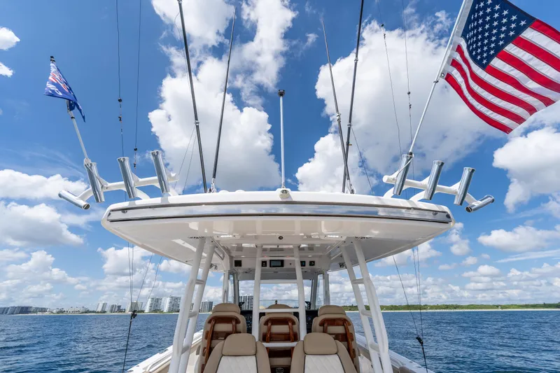 Golden Hour Yacht Photos Pics 2021 Everglades 395 Center Console boat with flags, under a bright blue sky.