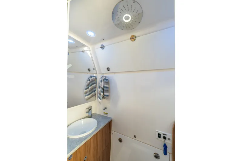 Golden Hour Yacht Photos Pics 2021 Everglades 395 Center Console bathroom with modern sink and striped towels.