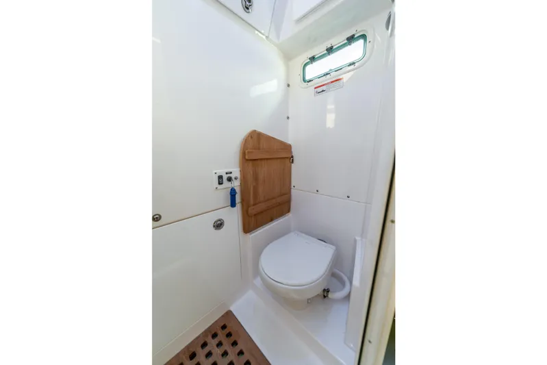 Golden Hour Yacht Photos Pics 2021 Everglades 395 Center Console boat bathroom with compact toilet and wooden accents.