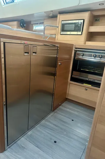 Mystic Impression Yacht Photos Pics 2022 Elan Impression 50.1 yacht kitchen with stainless steel appliances and modern wood cabinetry.