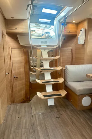 Mystic Impression Yacht Photos Pics 2022 Elan Impression 50.1 yacht interior with modern wooden staircase and seating area.