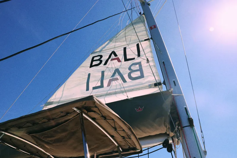 Wiley Pixie Yacht Photos Pics Sailing catamaran Bali CATSPACE 2023 with sunlit sails against a clear blue sky.