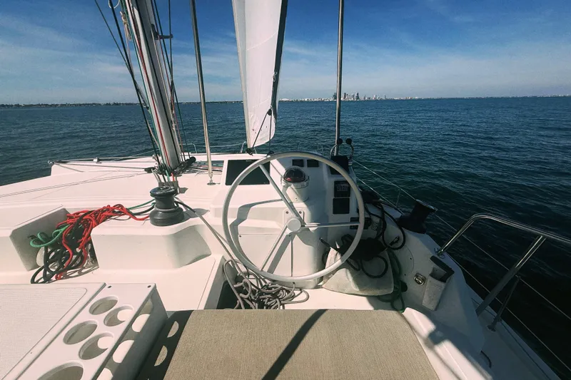 Wiley Pixie Yacht Photos Pics 2023 Bali CATSPACE sailboat cockpit with steering wheel, ropes, and ocean view.