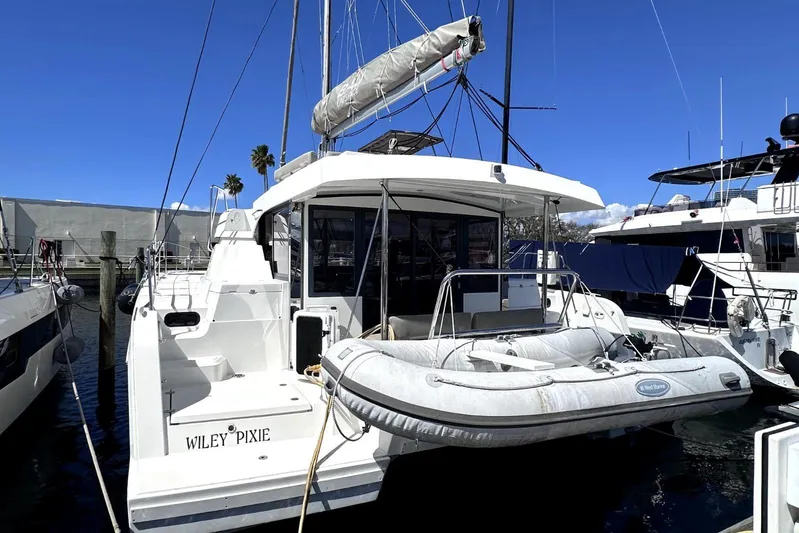Wiley Pixie Yacht Photos Pics 2023 Bali CATSPACE catamaran docked with inflatable boat, clear blue sky background.