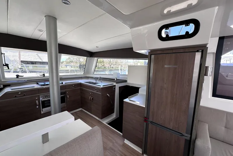 Wiley Pixie Yacht Photos Pics Modern kitchen interior of 2023 Bali CATSPACE catamaran with sleek wood finishes and ample natural light.
