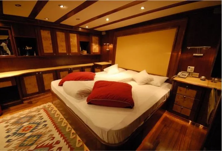 42 M Custom Made Motorsailor Yacht Photos Pics Luxurious bedroom in 2006 Custom Made 42 M Motorsailor with elegant wood finishes and cozy bedding.