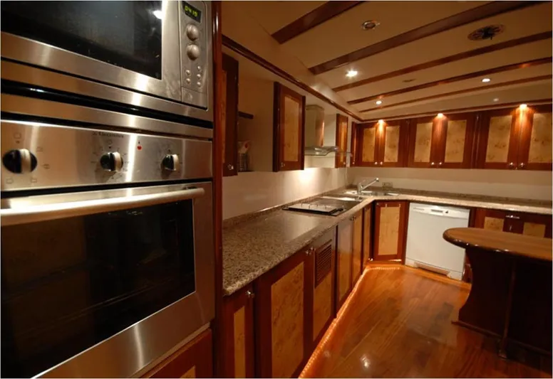 42 M Custom Made Motorsailor Yacht Photos Pics Luxurious kitchen interior of 2006 Custom Made 42 M Motorsailor with modern appliances and wood finish.