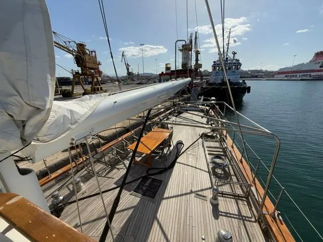 42 M Custom Made Motorsailor Yacht Photos Pics Custom Made 42 M Motorsailor, 2006, docked at a bustling harbor with cranes and ships.