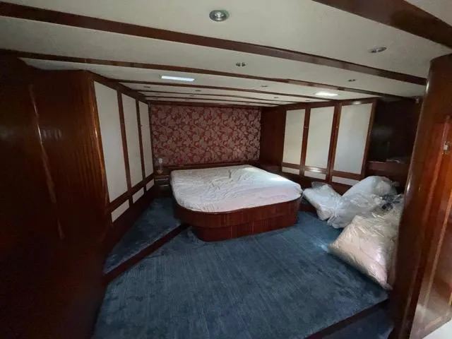 42 M Custom Made Motorsailor Yacht Photos Pics Luxurious bedroom in 2006 Custom Made 42 M Motorsailor with wood paneling and plush carpet.