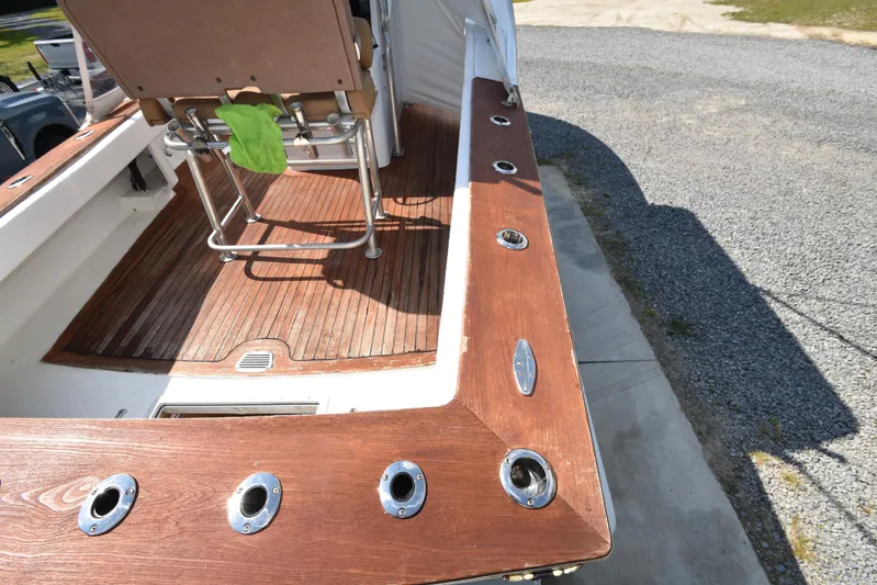 Double Trouble Yacht Photos Pics Custom Carolina 28 Cape Lookout boat deck with wooden finish and fishing rod holders, 2007 model.