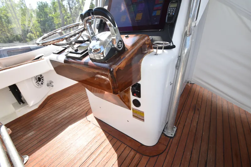 Double Trouble Yacht Photos Pics Helm of 2007 Custom Carolina 28 Cape Lookout boat, featuring polished controls and wooden accents.