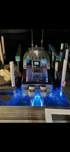 Double Trouble Yacht Photos Pics Custom Carolina 28 Cape Lookout boat docked at night, illuminated with blue underwater lights.