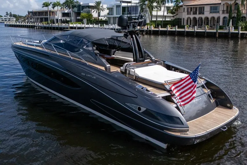  Yacht Photos Pics Luxurious 2015 Riva 63 yacht with American flag, docked near waterfront homes.