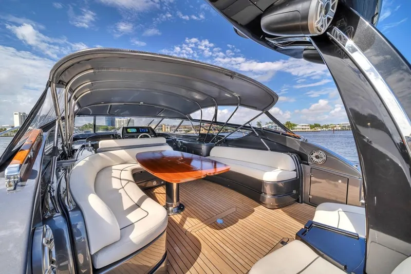  Yacht Photos Pics Luxurious 2015 Riva 63 yacht interior with elegant seating and wooden table under canopy.