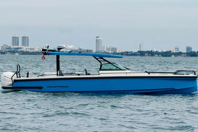 Out Of The Blue Yacht Photos Pics 2021 Axopar 37 Sun Top boat on water with city skyline in background.