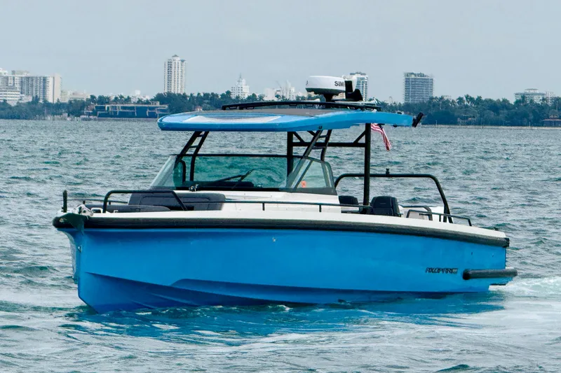 Out Of The Blue Yacht Photos Pics 2021 Axopar 37 Sun Top boat cruising on water with city skyline in background.