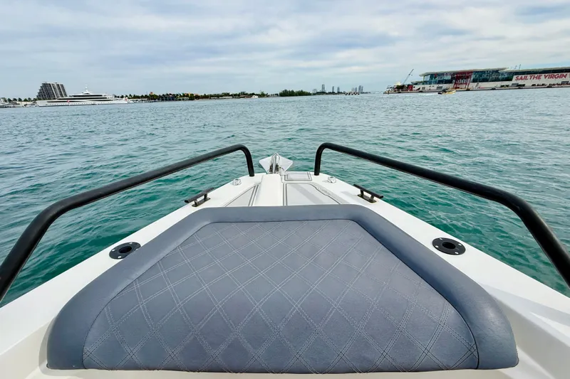 Out Of The Blue Yacht Photos Pics 2021 Axopar 37 Sun Top boat on water, featuring cushioned bow seating.