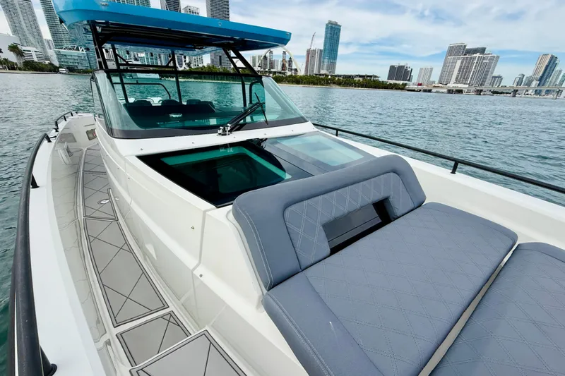 Out Of The Blue Yacht Photos Pics 2021 Axopar 37 Sun Top boat with city skyline in background.