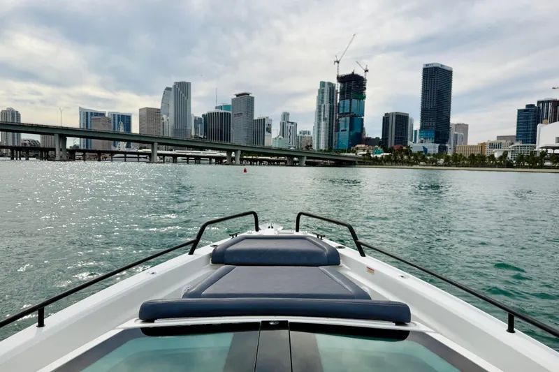 Out Of The Blue Yacht Photos Pics 2021 Axopar 37 Sun Top cruising near city skyline and bridge on a cloudy day.