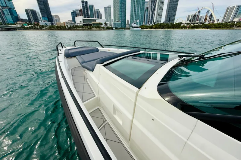 Out Of The Blue Yacht Photos Pics 2021 Axopar 37 Sun Top boat on water with city skyline in background.