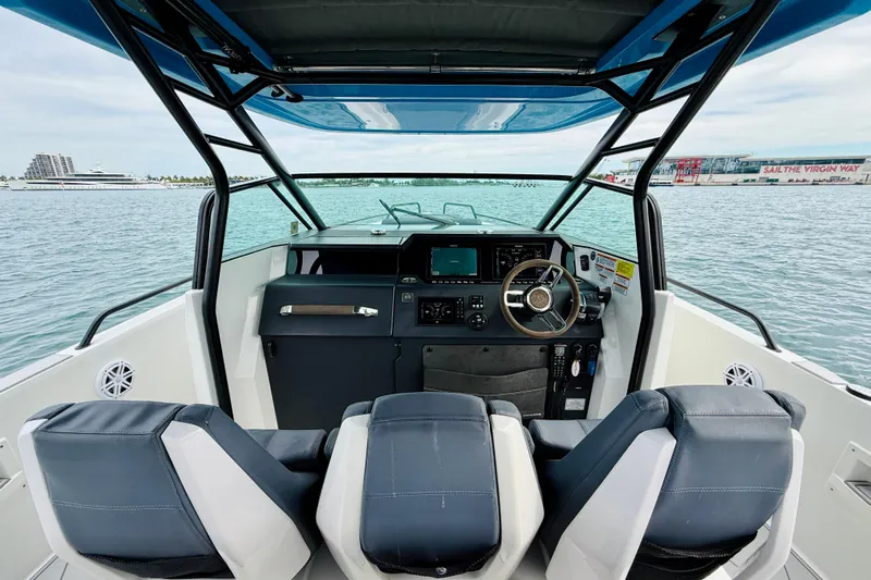 Out Of The Blue Yacht Photos Pics 2021 Axopar 37 Sun Top boat interior with steering wheel and navigation system.