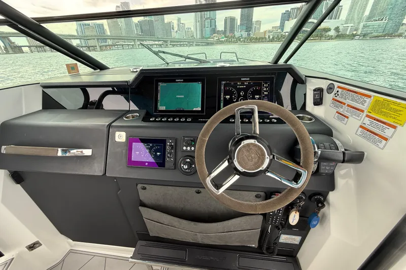 Out Of The Blue Yacht Photos Pics 2021 Axopar 37 Sun Top helm with modern navigation system and city skyline view.