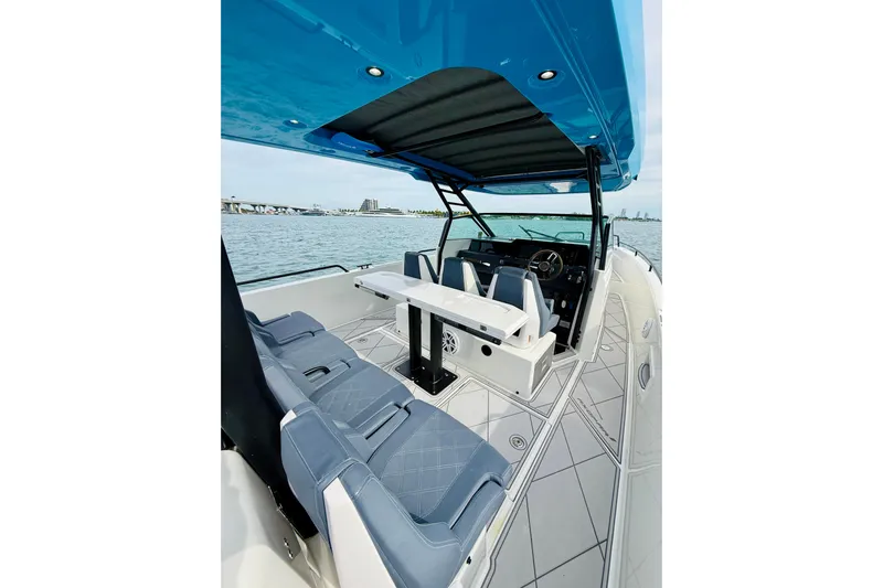 Out Of The Blue Yacht Photos Pics 2021 Axopar 37 Sun Top boat interior with seating and helm, overlooking water.