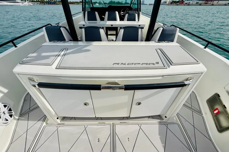 Out Of The Blue Yacht Photos Pics 2021 Axopar 37 Sun Top boat interior with seating and storage, on calm water.