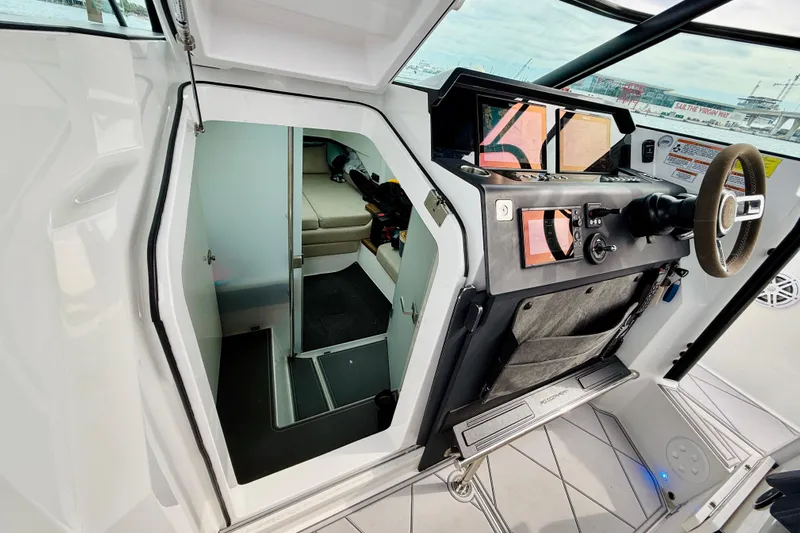 Out Of The Blue Yacht Photos Pics 2021 Axopar 37 Sun Top helm with cabin entrance, featuring modern controls and seating.