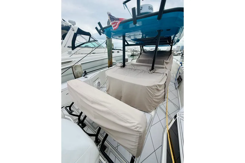 Out Of The Blue Yacht Photos Pics 2023 Axopar 37 Sun Top boat with covered seating, docked at a marina.