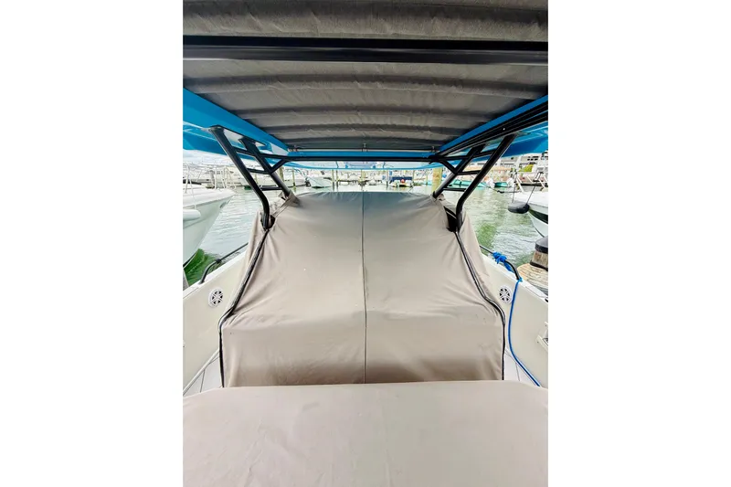 Out Of The Blue Yacht Photos Pics 2023 Axopar 37 Sun Top boat with covered seating area at a marina.