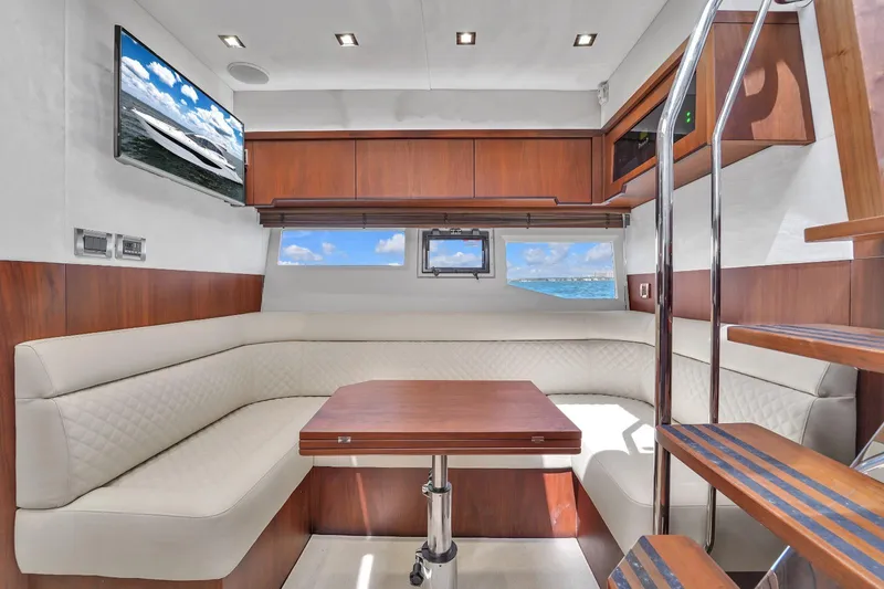  Yacht Photos Pics Luxurious interior of 2017 Galeon 445 HTS yacht with white leather seating and wooden table.