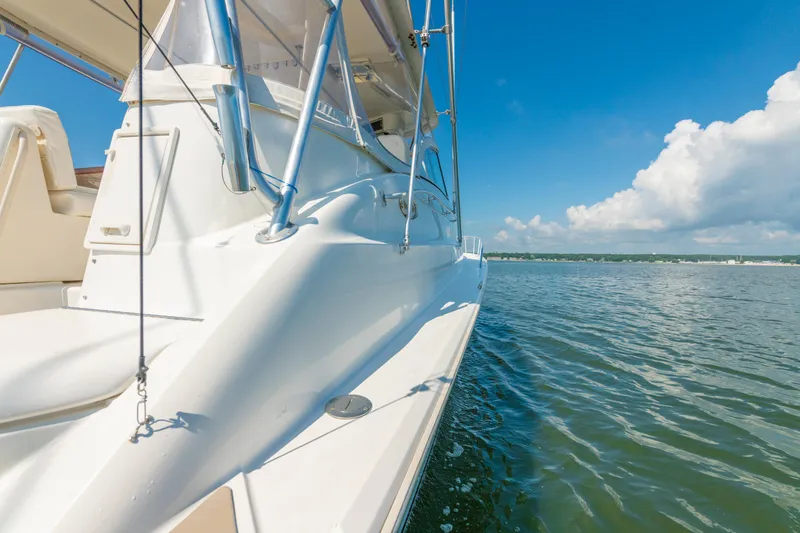 Alexa Corinne Yacht Photos Pics 1999 Ocean Yachts 48 Express cruising on calm waters under a clear blue sky.