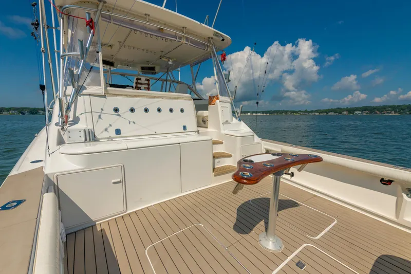 Alexa Corinne Yacht Photos Pics 1999 Ocean Yachts 48 Express boat deck with fishing setup, on a sunny day.