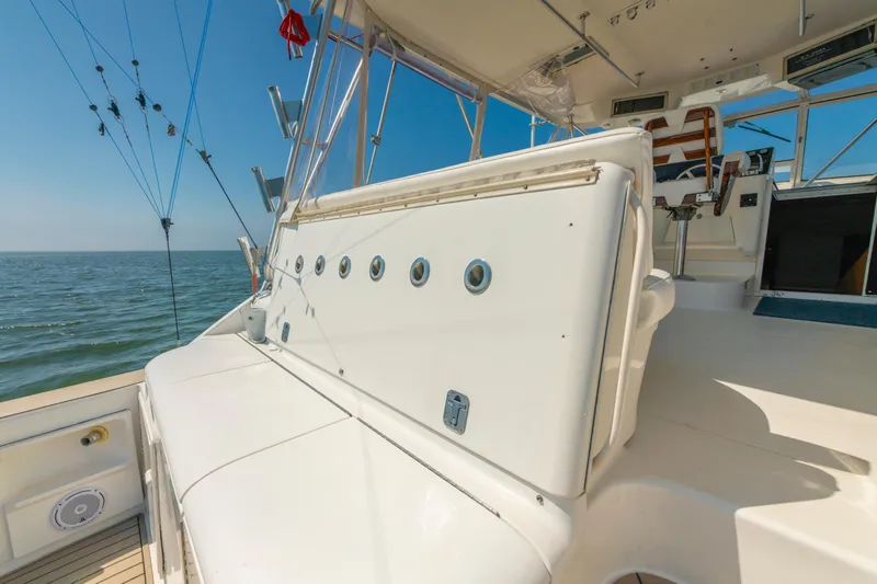 Alexa Corinne Yacht Photos Pics 1999 Ocean Yachts 48 Express boat deck with fishing rods, ocean view, and seating area.