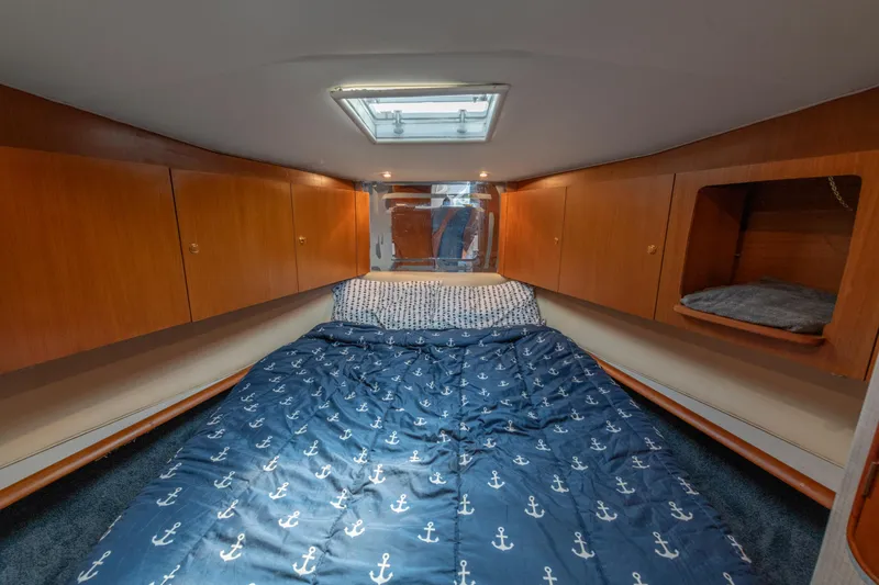 Alexa Corinne Yacht Photos Pics 1999 Ocean Yachts 48 Express cabin with wooden cabinets and anchor-patterned bedding.