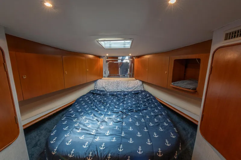 Alexa Corinne Yacht Photos Pics 1999 Ocean Yachts 48 Express cabin with cozy bed and wooden storage cabinets.