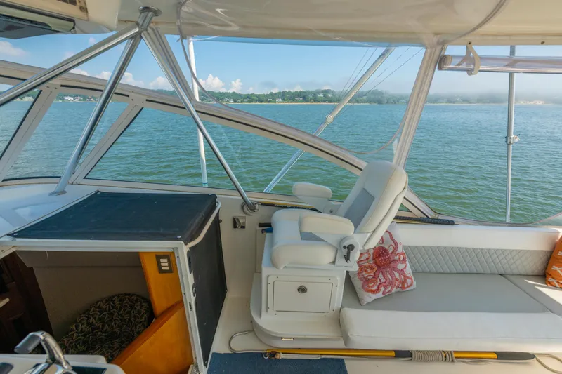 Alexa Corinne Yacht Photos Pics 1999 Ocean Yachts 48 Express interior with white seating, overlooking serene water and distant shoreline.