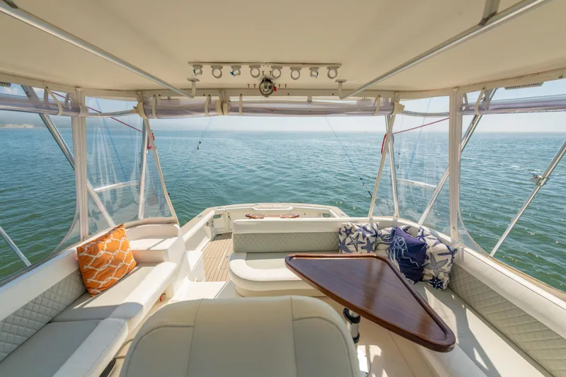 Alexa Corinne Yacht Photos Pics 1999 Ocean Yachts 48 Express interior with ocean view, featuring comfortable seating and decorative pillows.