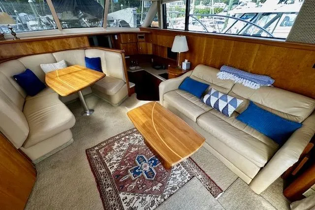  Yacht Photos Pics 2001 Silverton 42 Convertible yacht interior with beige seating, wooden tables, and decorative pillows.