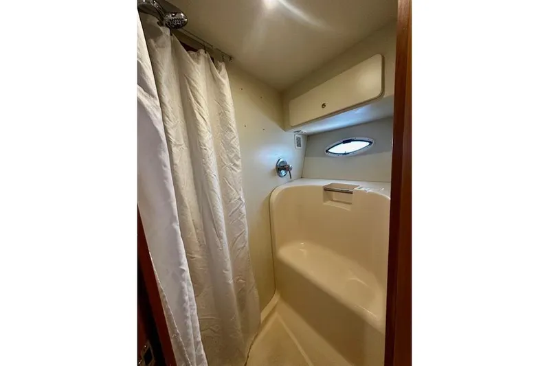  Yacht Photos Pics Shower area in 2001 Silverton 42 Convertible yacht with curtain and porthole window.