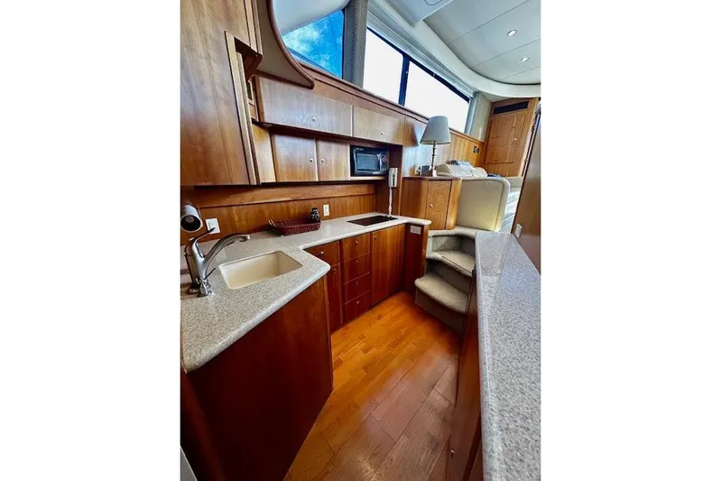  Yacht Photos Pics Luxurious 2001 Silverton 42 Convertible yacht interior with modern kitchen and wood cabinetry.