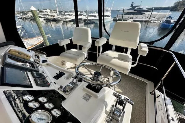 Yacht Photos Pics 2001 Silverton 42 Convertible yacht cockpit with steering wheel, gauges, and marina view.