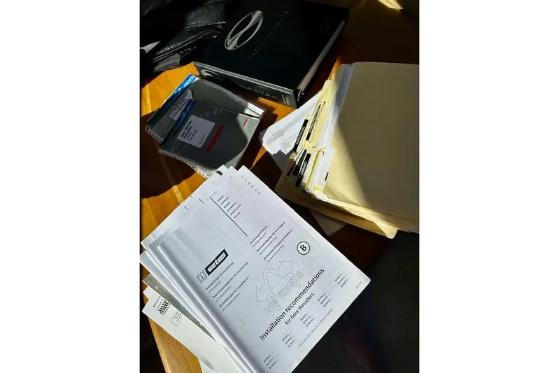  Yacht Photos Pics Documents and folders on a table, including installation recommendations for a 2001 Silverton 42 Convertible.