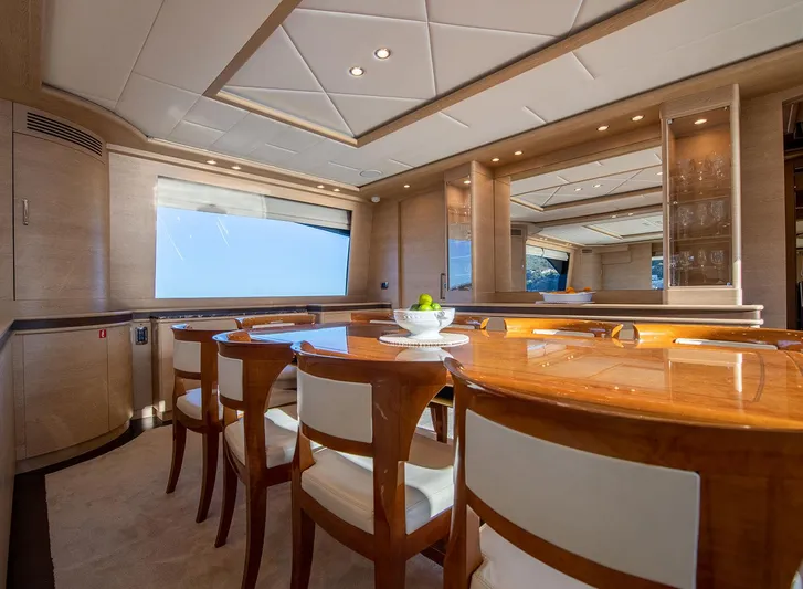 Grace Yacht Photos Pics Luxurious dining area on 2009 Astondoa 96 GLX yacht with elegant wooden table and chairs.