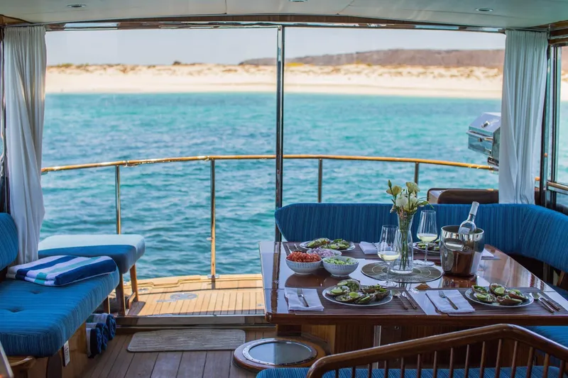 New School Yacht Photos Pics Luxurious dining setup on 1966 Chris-Craft 57 Constellation yacht with ocean view.