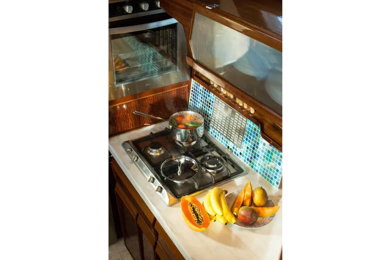 New School Yacht Photos Pics Galley kitchen in 1966 Chris-Craft 57 Constellation with stove, fruit, and vibrant backsplash.